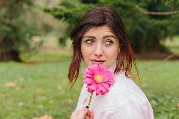 Attractive woman with gerbera smiling