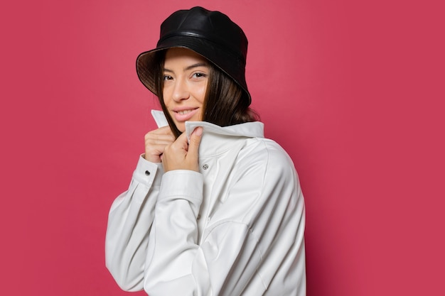 Free photo attractive  woman with perfect  smile dressed in stylish cap and white jacket posing on pink background. isolate.