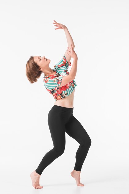 Attractive young female dancer posing in front white background