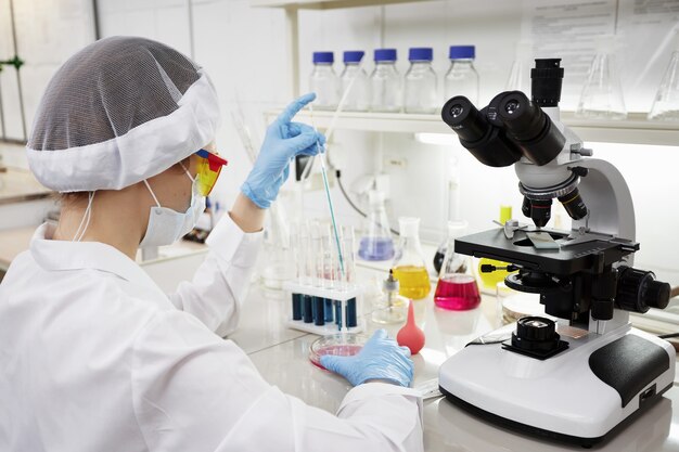 Attractive young PhD student scientist observing the blue indicator color shift in the glass tube