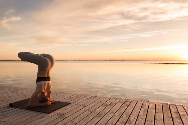 Attractive young sports lady make yoga exercises.