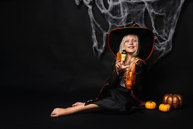 Free photo attractive young witch with toys and pumpkins