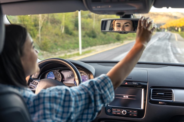 Free photo attractive young woman driving a car view from inside