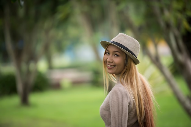 Attractive young woman enjoying her time outside in park with nature park background.