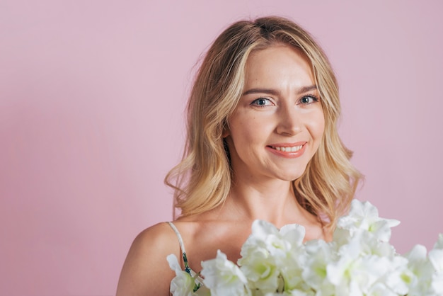 An attractive young woman holding fresh white flower