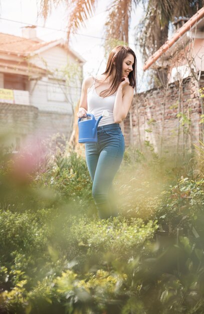 An attractive young woman looking at green plants in the greenhouse