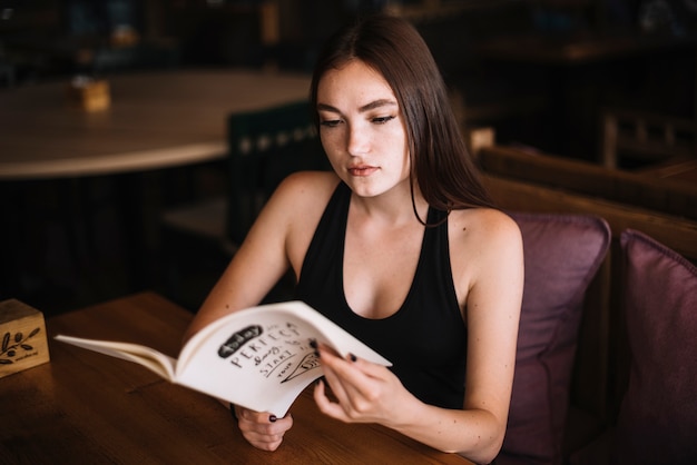 Attractive young woman looking at menu in the restaurant