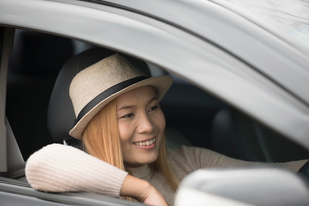 Free photo attractive young woman sitting in the car open the window enjoy nature.