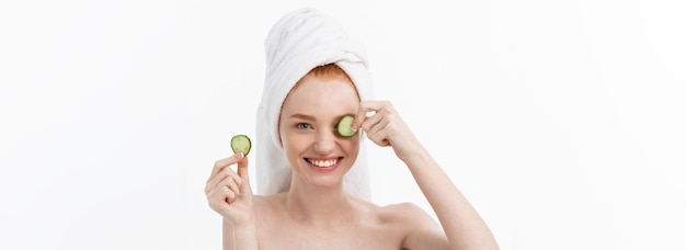 Free photo attractive young woman with beautiful clean skin white mask and cucumbers beauty treatments and cosm