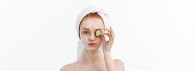 Free photo attractive young woman with beautiful clean skin white mask and cucumbers beauty treatments and cosm