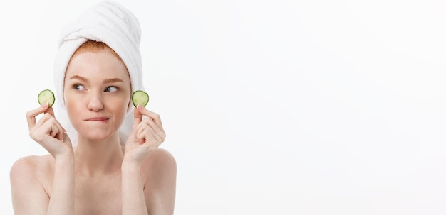 Free photo attractive young woman with beautiful clean skin white mask and cucumbers beauty treatments and cosm