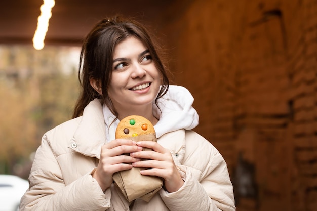 Free Photo attractive young woman with gingerbread on a blurred background copy space