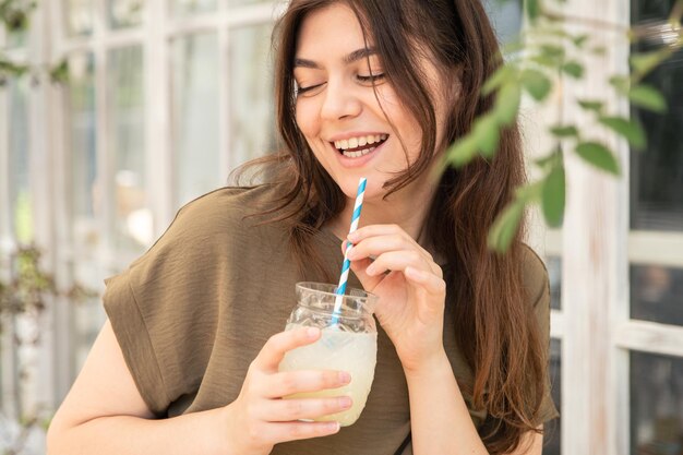 Attractive young woman with a glass of lemonade on a hot summer day