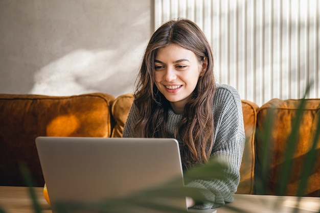 Attractive young woman working on a laptop early in the morning