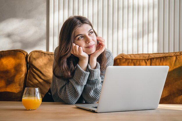 Attractive young woman working on a laptop early in the morning