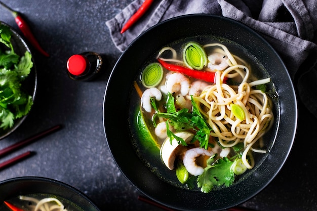 Authentic Asian noodle soup in a black bowl