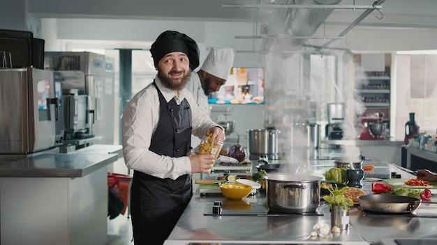 Authentic cook doing cooking show lesson on camera in kitchen, preparing gourmet meal with culinary recipe. Man recording dish preparations on camera for gastronomy television program.