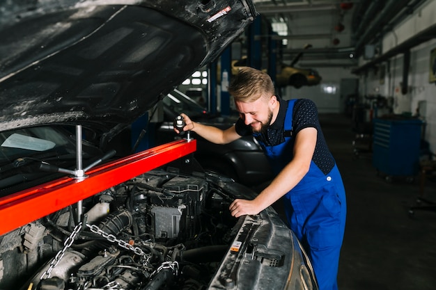 Free Photo auto mechanic hoisting out car's engine 