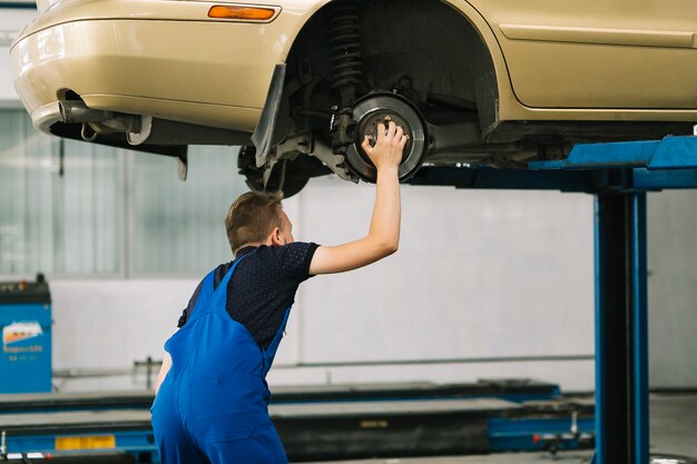 Auto mechanic holding hob on car 