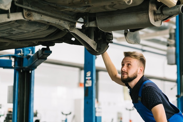 Free Photo auto mechanic looking car's bilge