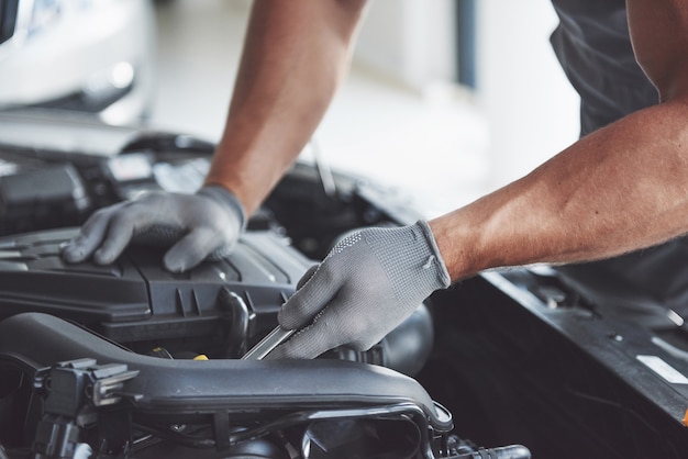 Auto mechanic working in garage. Repair service.