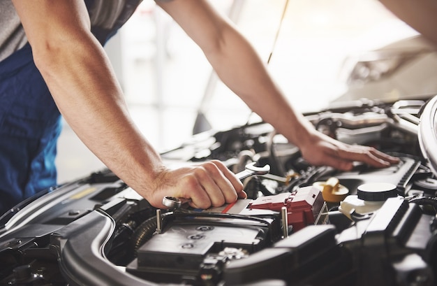 Auto mechanic working in garage. Repair service.