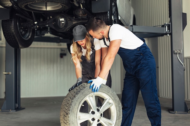 Free photo auto service employees pushing wheel