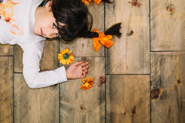 Free photo autumn concept with small girl lying on the floor