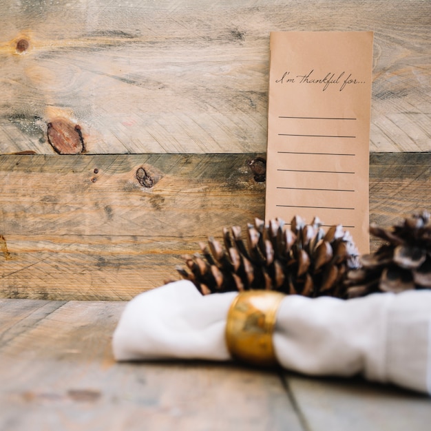 Free photo autumn decoration with menu and pine cones