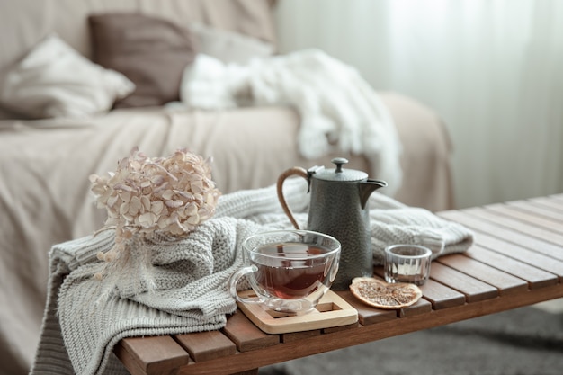 Autumn home composition with a cup of tea, a teapot and a knitted element.