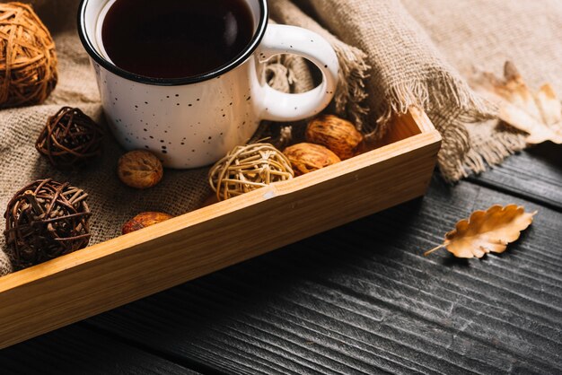 Autumn leaf near tray with mug and decorations