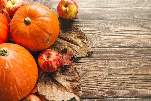 Free Photo autumn pumpkins on wooden table with leaves