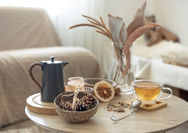 Autumn still life with tea on the table in the interior of the room, copy space.