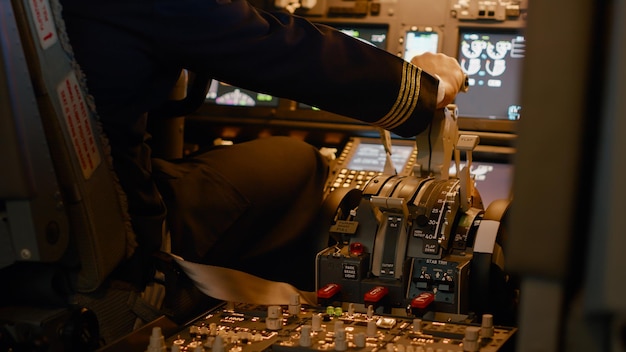 Free Photo aviation crew flying airplane with engine lever to throttle, using dashboard command buttons to takeoff. control panel navigantion and windscreen to fly plane, using power handle. close up.