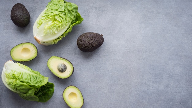 Avocados with lettuce on table