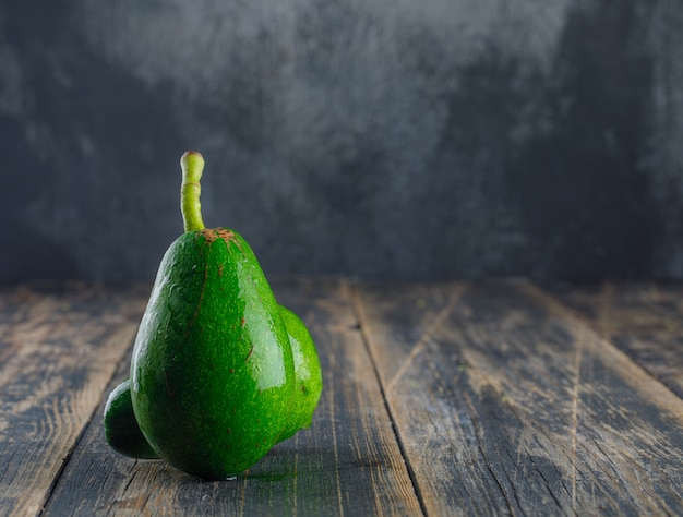 Avocados on wooden and plaster wall. side view.