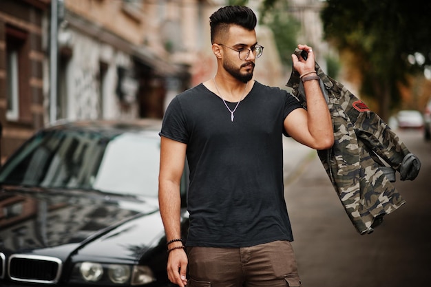 Free photo awesome beautiful tall ararbian beard macho man in glasses and black tshirt walking against business car