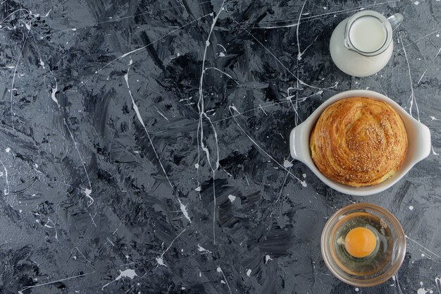 Azerbaijan national pastry with uncooked chicken egg and a glass pitcher of fresh milk 