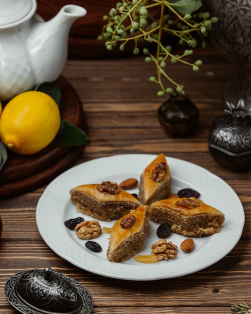 Free Photo azerbaijani dessert pakhlava with nuts and sultana inside white plate.