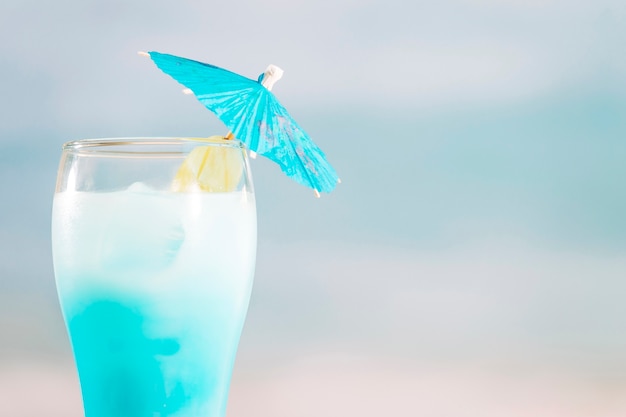 Azure cocktail with umbrella in glass