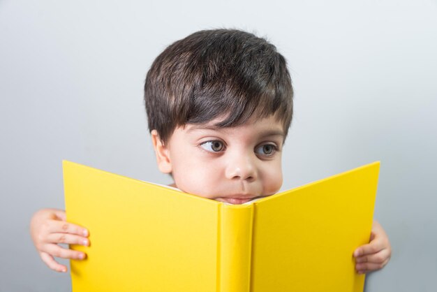 Baby boy reading yellow book