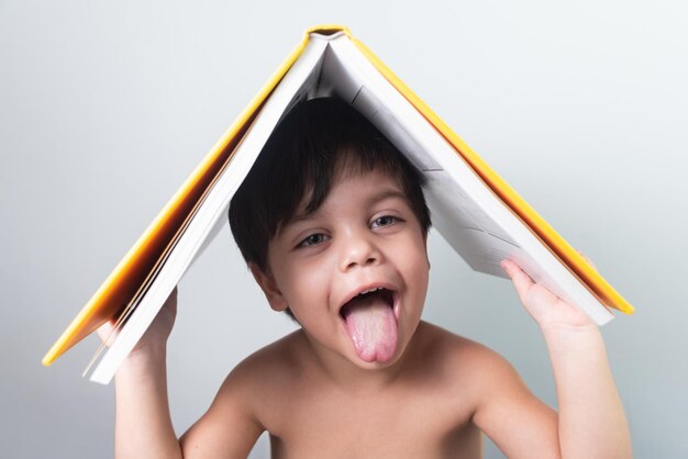 Baby boy with yellow book on his head