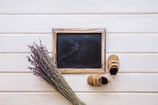 Baby concept with slate and branches on wooden surface