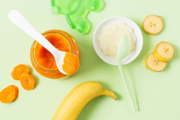 Baby food on green background flat lay