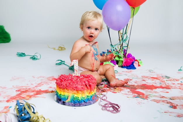 Baby girl celebrating her first bithday with gourmet cake and ba