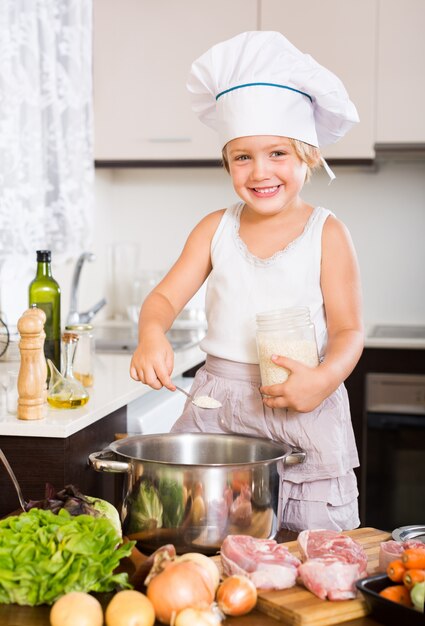 Baby girl cooking with meat