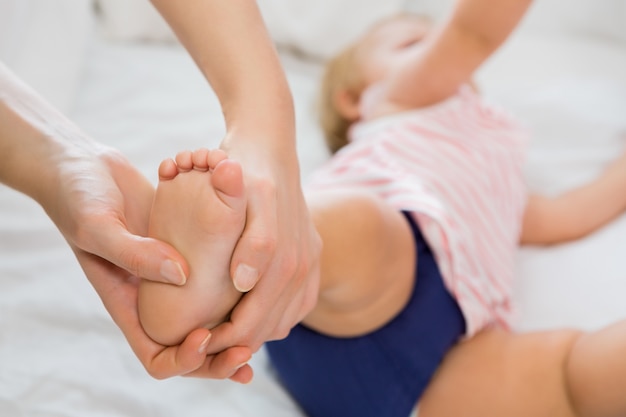 Baby girl receiving massage from mother