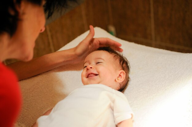 Baby girl two months old smiling to her mother at home