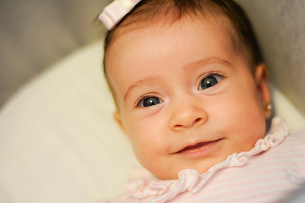 Baby girl two months old smiling indoors