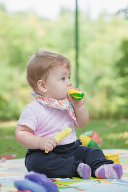 Baby, less than a year old   playing with  toy banana